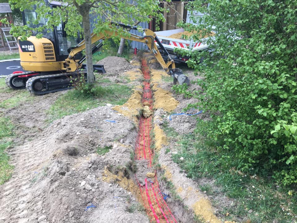 Chantier d'assainissement avec pelleteuse pour le raccordement et l'installation de canalisations par une entreprise de travaux publics à Richelieu.