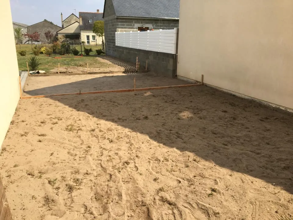Terrain de terrassement préparé pour l'aménagement extérieur à côté d'une maison.