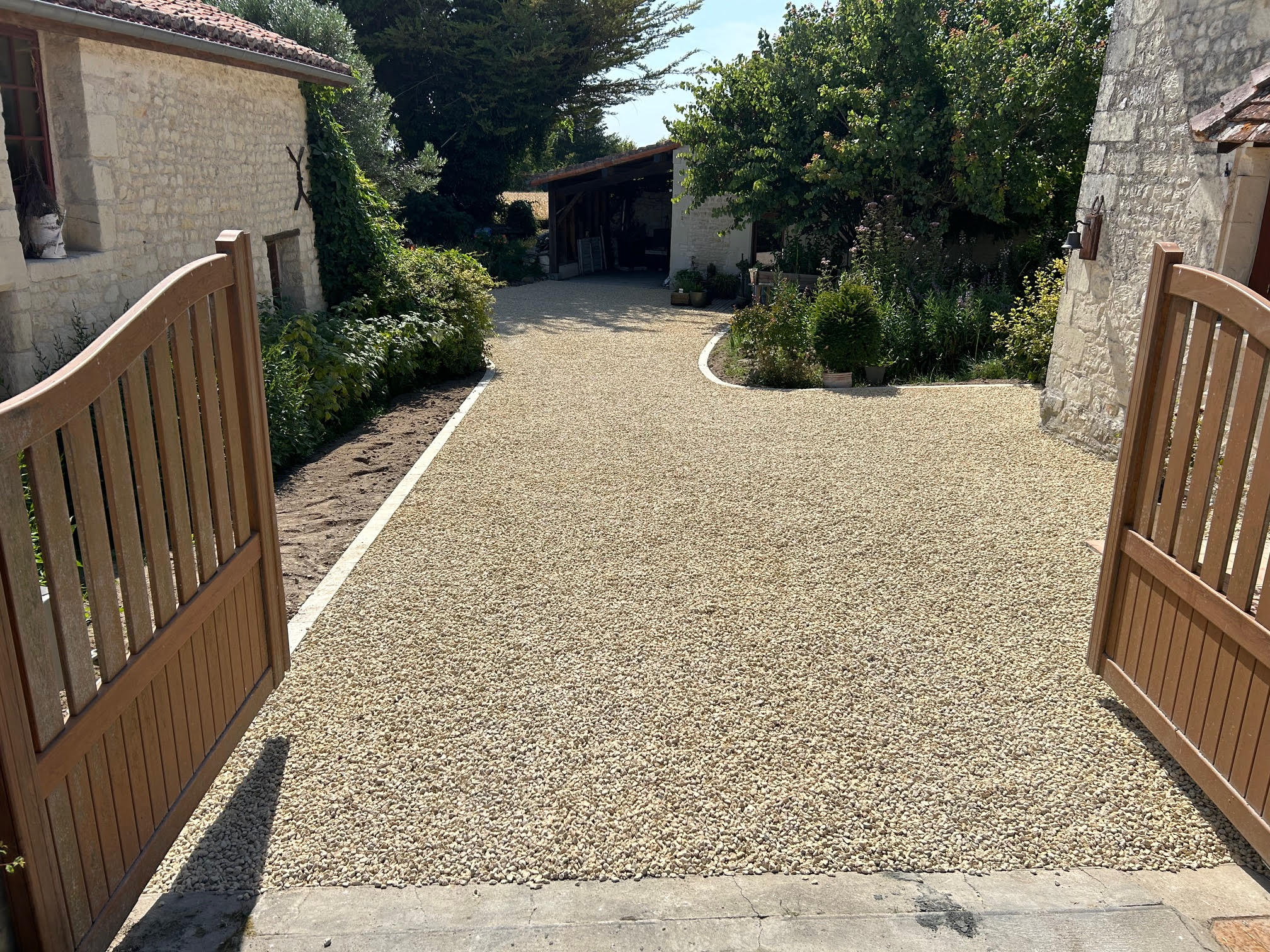 Aménagement extérieur avec muret en pierres pour délimiter un espace dans un jardin.