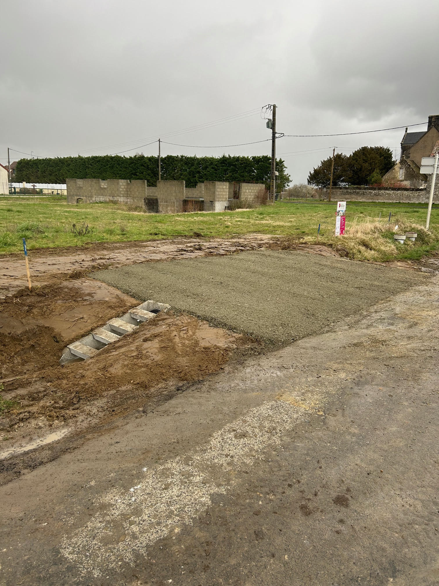 Pelleteuse de chantier effectuant des travaux de terrassement près d'une maison. 
